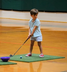 a boy playing mini golf