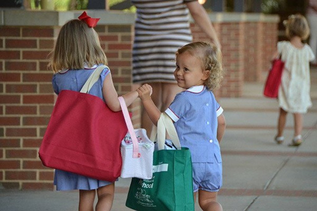 a couple of young girls carrying shopping bags.